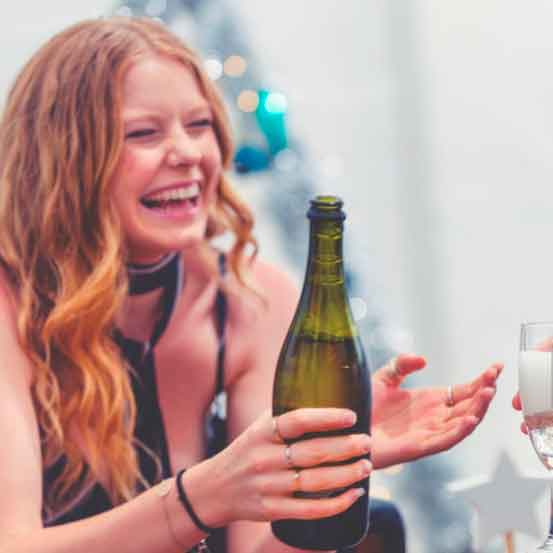 Hymyilevä tyttö valmistautuu Prosecco Pong -peliin.